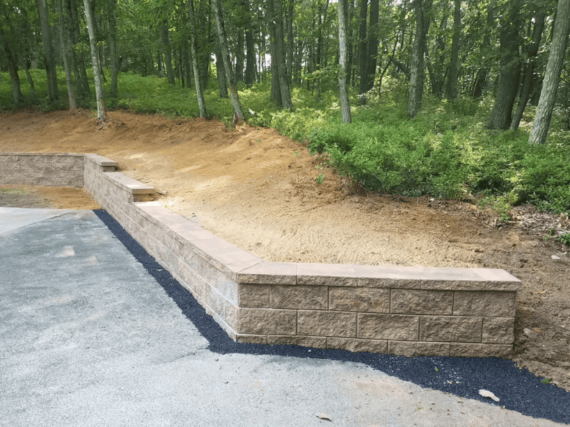 Completed retaining wall project in East Hanover NJ for exterior drainage support, grading, and above-grade waterproofing by Down Under Waterproofing